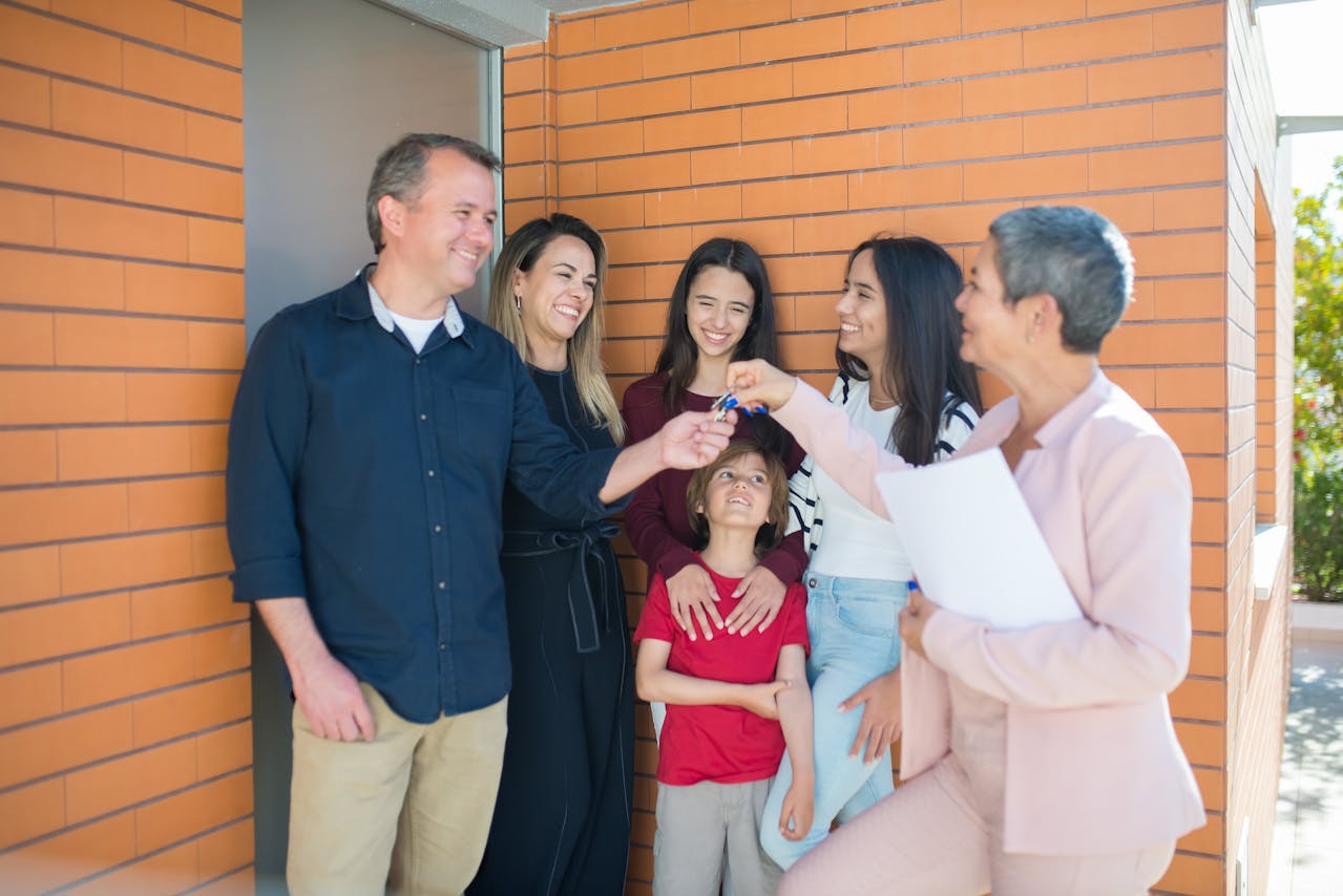 Happy family standing outside their newly purchased home on a sunny day